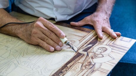 Ikonenmaler Naser Abdallah Jildah arbeitet an einer seiner Brandmalerei-Ikonen / © Andrea Krogmann (KNA)