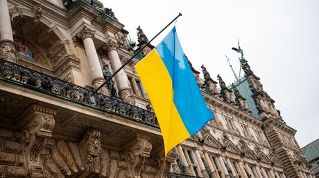Eine Flagge der Ukraine hängt am Hamburger Rathaus / © Daniel Bockwoldt (dpa)