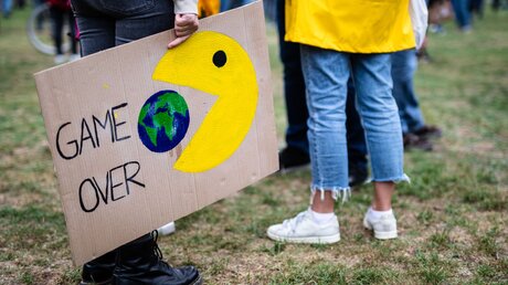 "Game Over" steht beim globalen Klimastreik der Klimaschutzbewegung Fridays for Future auf dem Plakat einer Teilnehmerin geschrieben / © Christoph Schmidt (dpa)