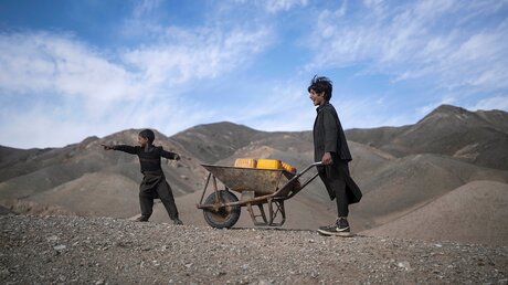 Zwei Brüder in Afghanistan machen sich mit Kanister in einer Schubkarre auf den Weg, um Wasser aus einem stehenden See zu holen / © Petros Giannakouris (dpa)