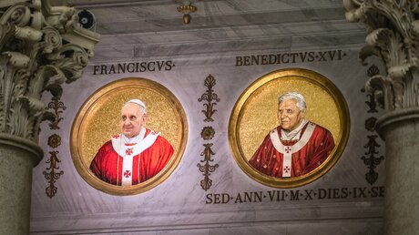 Das Medaillon von Papst Franziskus (l.) neben dem von Vorgänger Papst Benedikt XVI. in der Kirche Sankt Paul vor den Mauern in Rom. / © Stefano Dal Pozzolo/Romano Siciliani (KNA)