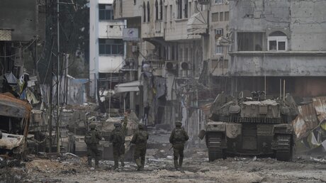 Israelische Soldaten gehen eine Straße entlang während einer Bodenoperation im Gazastreifen / © Victor R. Caivano/AP/dpa (dpa)