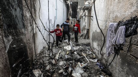 Palästinensische Gebiete, Rafah: Palästinensische Kinder begutachten ein beschädigtes Haus nach einem israelischen Bombardement / © Abed Rahim Khatib (dpa)