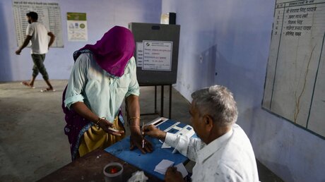 Eine Frau bereitet sich auf die Stimmabgabe während des ersten Wahlgangs der indischen Parlamentswahlen in Neemrana im indischen Bundesstaat Rajasthan vor / © Manish Swarup (dpa)