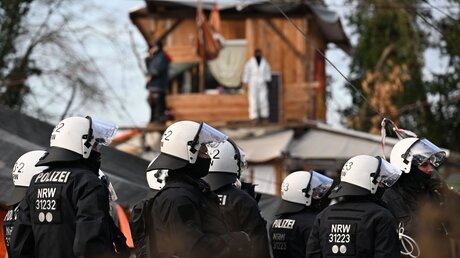  Eine Gruppe Polizisten steht bei der Räumung von Lützerath vor Bretterhütten, die von Aktivisten und Demonstranten gebaut worden waren / © Federico Gambarini (dpa)