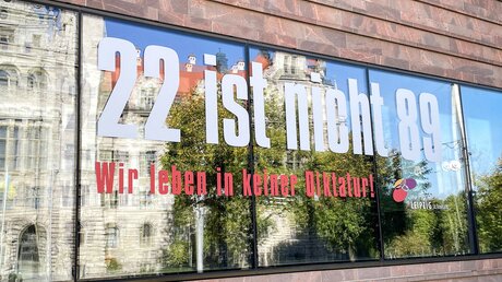 An der Fensterfront des Gemeindehauses der Propsteikirche Sankt Trinitatis in Leipzig steht der Schriftzug "22 ist nicht 89. Wir leben in keiner Diktatur!", am 9. Oktober 2022. / © Karin Wollschläger (KNA)