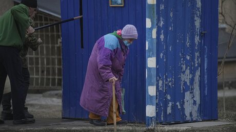 Ukraine, Schtschastja: Eine Alte Dame geht während eines Beschusses in der Region Luhansk eine Straße entlang um Wasser aus einem Brunnen zu holen / © Vadim Ghirda (dpa)