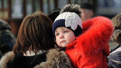 Ukraine, Lwiw: Eine Frau trägt ihr Kind am Bahnhof von Lwiw / © Mykola Tys (dpa)