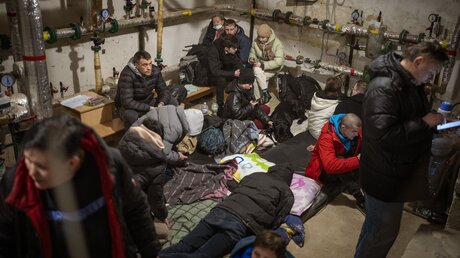 Menschen in Kiew suchen Schutz in einem Keller eines Gebäudes, während die Sirenen neue Angriffe ankündigen / © Emilio Morenatti (dpa)