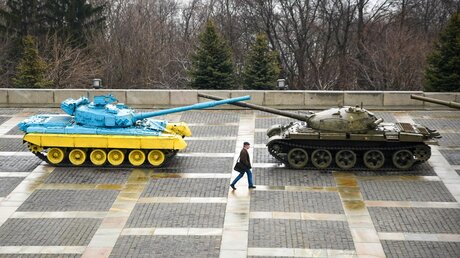 Ukraine, Kiew: Ein Mann geht an zwei Panzern vorbei die nahe der Mutter-Heimat-Statue stehen / © Madeleine Kelly (dpa)