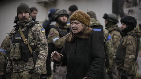 Ukraine, Butscha: Eine ältere Frau geht an ukrainische Soldaten vorbei / © Vadim Ghirda (dpa)