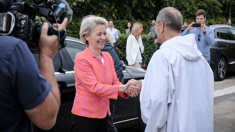 Frere Alois Löser, Prior der Communaute von Taize, begrüßt Ursula von der Leyen, Präsidentin der Europäischen Kommission / © Oliver Sittel (KNA)