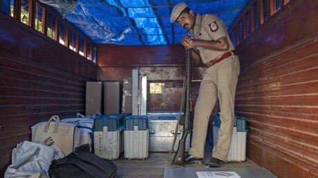 Ein indischer Polizist bewacht Wahlmaterial auf einem Lastwagen / © Altaf Qadri (dpa)