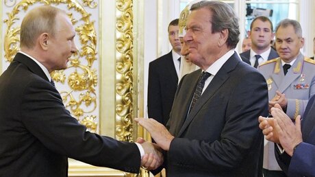 Russland, Moskau: Gerhard Schröder (r), ehemaliger deutscher Bundeskanzler, gibt Wladimir Putin (l), Präsident von Russland, bei dessen Amtseinführung im Kreml die Hand.  / © Alexei Druzhinin (dpa)