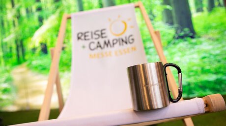 Segensbecher des Bistums Essen auf einem Liegestuhl der Reisemesse "Reise + Camping" (Bistum Essen)