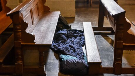 Ein Schlafsack liegt zwischen zwei Kirchenbänken / © Harald Oppitz (KNA)