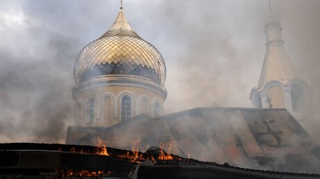 Ukraine, Kupjansk: Nach einem Angriff, mutmaßlich von russischer Seite, ist ein Feuer ausgebrochen, das auch die ukrainisch-orthodoxe St.-Nikolaus-Kirche bedroht.  / © Ashley Chan (dpa)