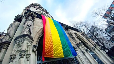 Eine große Regenbogenfahne hängt vom Kirchturm der Kirche Sankt Agnes in Köln. / © Klaus Nelissen (KNA)