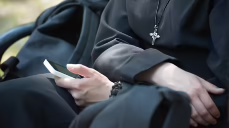 Eine Ordensschwester benutzt ein Smartphone / &copy; Serhii Yevdokymov (shutterstock)