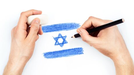 Symbolbild Ein Mann zeichnet die israelische Fahne / © Vladyslav Starozhylov (shutterstock)