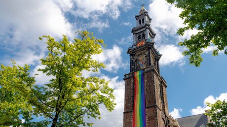 Kirche in Amsterdam mit Regenbogen-Fahne (shutterstock)
