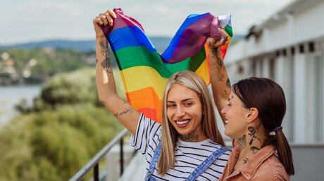 Homosexuelles Paar mit Regenbogenfahne / © bbernard (shutterstock)