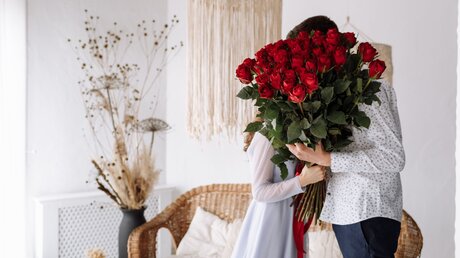 Ein Paar mit einem Strauss roter Rosen / © Andrii Medvediuk (shutterstock)