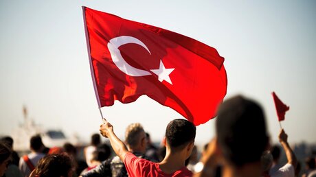 Ein Mann schwenkt eine türkische Fahne / © arda savasciogullari (shutterstock)