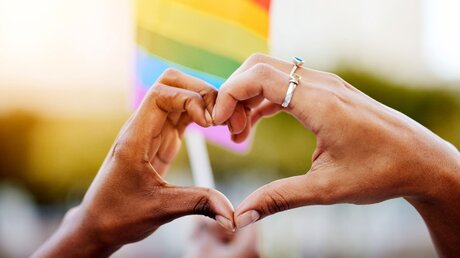 Homosexuelles Paar und eine Regenbogenfahne / © PeopleImages.com - Yuri A (shutterstock)