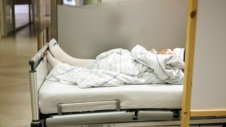 Ein Patient liegt in einem Bett in der Notaufnahme