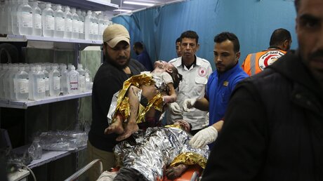 Palästinensische Kinder, die durch israelischen Beschuss verwundet wurden, werden am 24.03.2024 in ein Krankenhaus in Rafah gebracht. / © Hatem Ali/AP (dpa)
