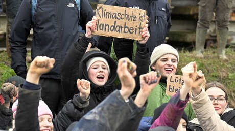Umweltaktivistin Luisa Neubauer (M) protestiert während einer Demonstration gegen den Kohleabbau am zweiten Tag der Räumung im von Klimaaktivisten besetzten Braunkohleort Lützerath. / © Roberto Pfeil (dpa)