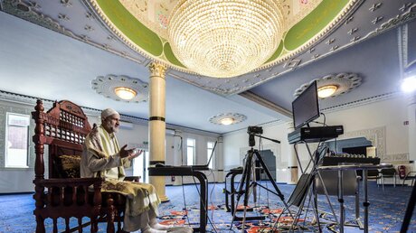 Imam Mohamed Amim Rachid sitzt im Gebetsraum der Salahu d-Din-Moschee in Essen / © Kerstin Kokoska (dpa)