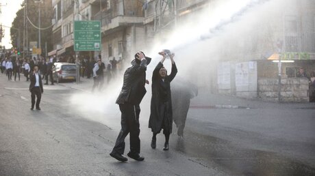 Ultraorthodoxe im Strahl eines Wasserwerfers der Polizei  / © Oded Balilty/AP/dpa (dpa)