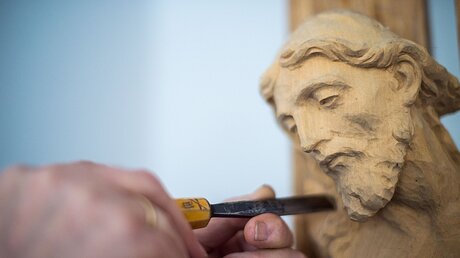 Jesusfigur wird mit einem Schnitzeisen bearbeitet / © Lino Mirgeler (dpa)