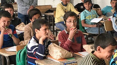 Schüler essen während einer Schulspeisung im Flüchtlingscamp Zaatari, an der Grenze zu Syrien / © Burkhard Jürgens (KNA)
