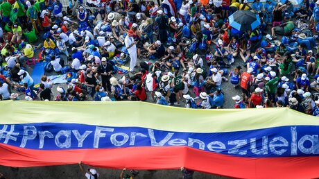 Jugendliche halten ein großes Banner mit der Aufschrift #Pray For Venezuela (dt. betet für Venezuela) / © Cristian Gennari (KNA)