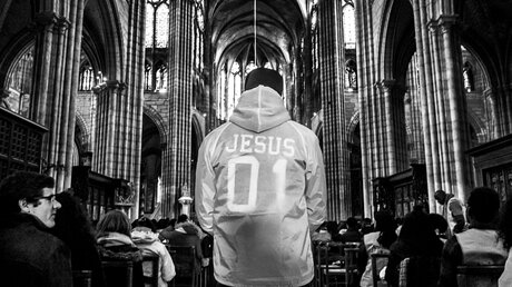 Jugendlicher mit Jesus-Jacke in der Kathedrale des Pariser Vororts Saint-Denis  / © Michael Bunel (KNA)