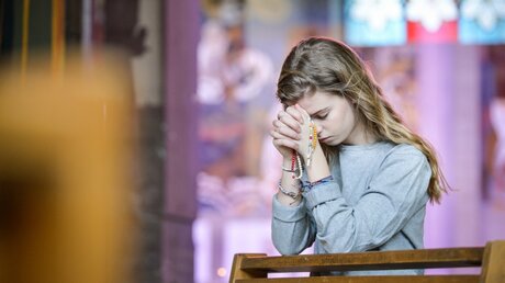 Junge Frau im Gebet / © Corinne Simon (KNA)