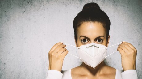 Junge Frau mit einer medizinischen Schutzmaske / © marvelens (shutterstock)