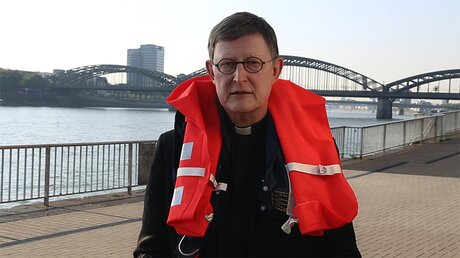 Rainer Maria Kardinal Woelki mit einer Rettungsweste (DR)