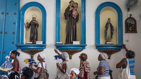 Gläubige ziehen in kubanischer Kirche an Heiligenfiguren vorbei / © Jeoffrey Guillemard (KNA)