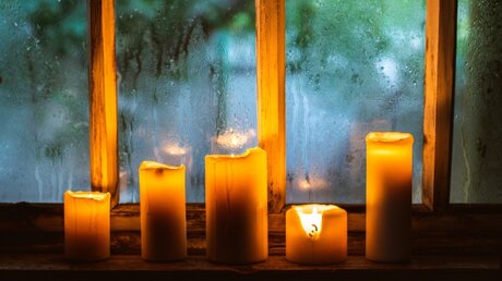 Kerzen vor einem Fenster / © Juliya Shangarey (shutterstock)