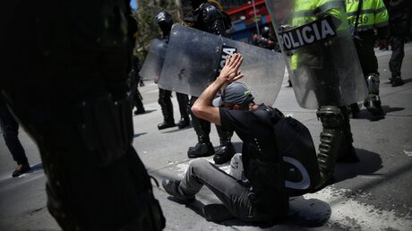 Kolumbien: Ein Demonstrant von Polizisten umringt / © Sergio Acero (dpa)
