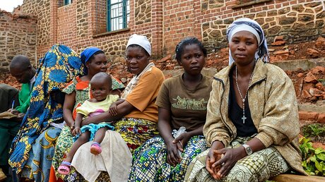 Frauen sitzen im Hof des Pfarrzentrums von Kabare (Kongo) auf einer Bank (KNA)