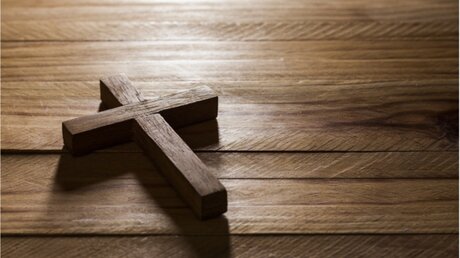 Kreuz auf einem Holztisch / © Carlos andre Santos (shutterstock)