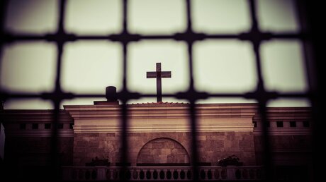 Kreuz hinter Gitterstäben / © Jeremiah Castelo (shutterstock)