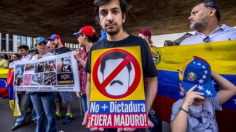 "Keine Diktatur mehr - Maduro raus!", steht auf dem Plakat eines Demonstranten / © Cris Faga (dpa)