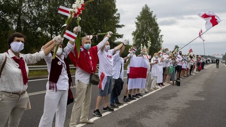 Litauen, Medininkai: Menschen halten sich an den Händen und bilden eine Menschenkette / © Mindaugas Kulbis (dpa)
