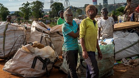 Männer, die Müll fürs Recycling sammeln, warten in Soweto auf die Bezahlung / © Jerome Delay (dpa)